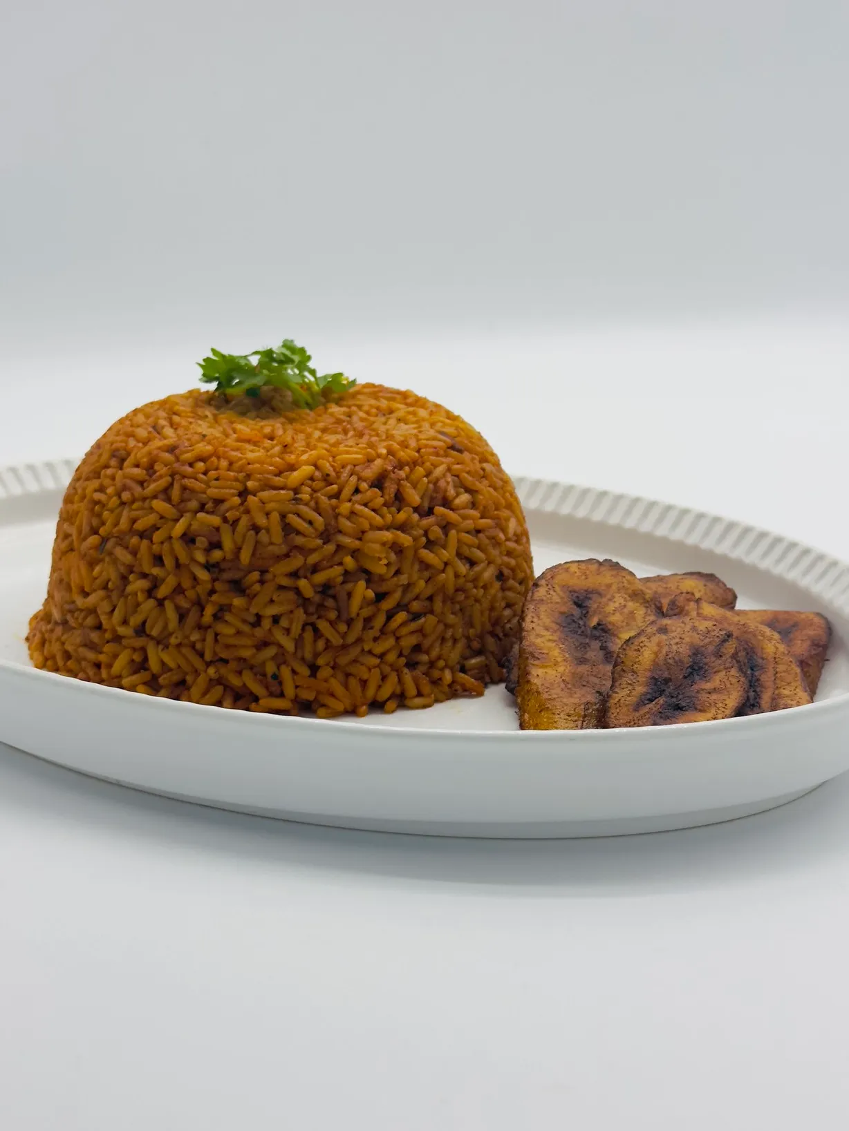 Jollof Rice with plantain at Dextera 9ja Cuisine in Middletown, MD 21769 | YourMenu Online Ordering