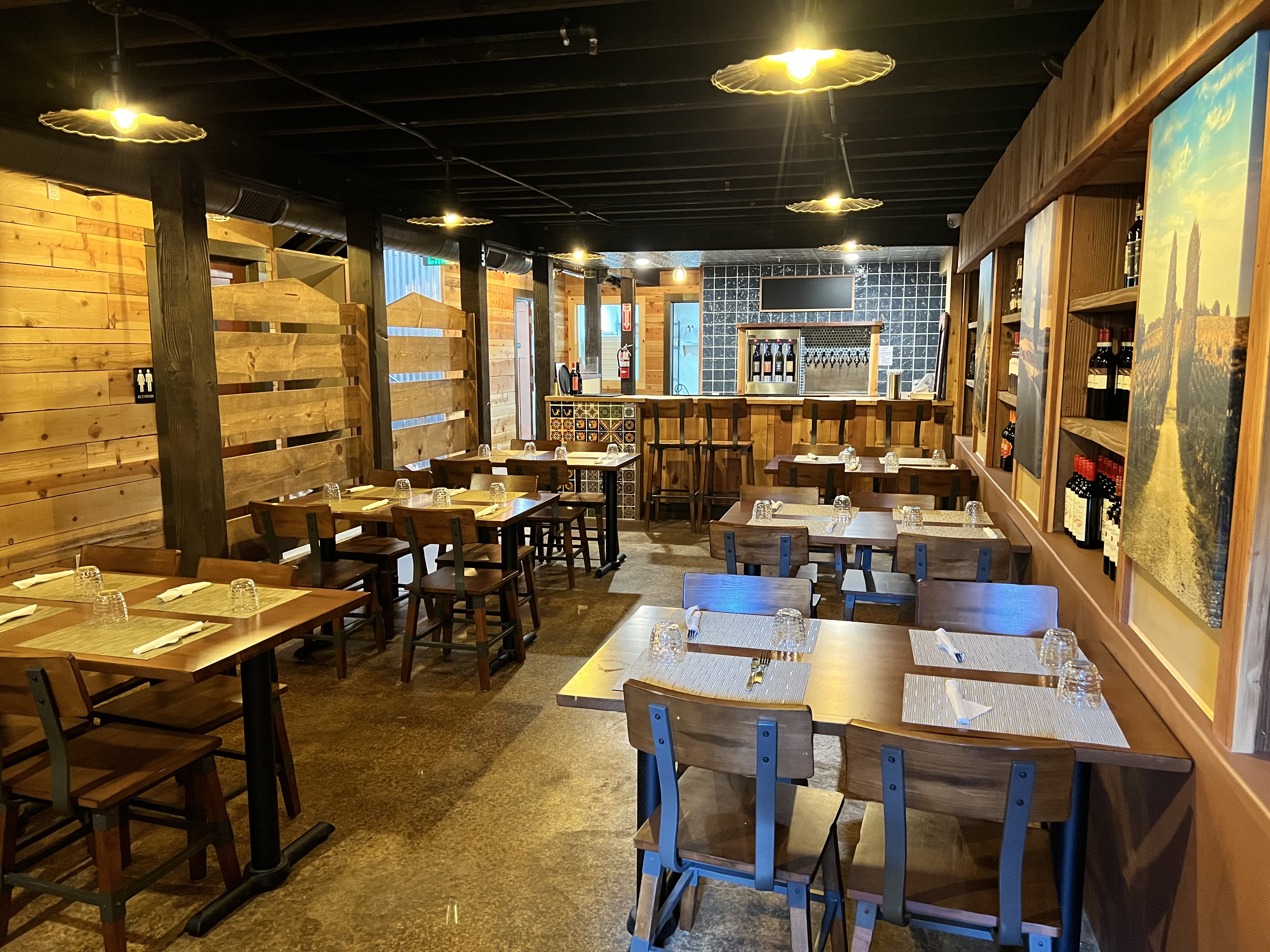 The dining room at Centro Orange: wooden tables, the bar and framed art on the walls